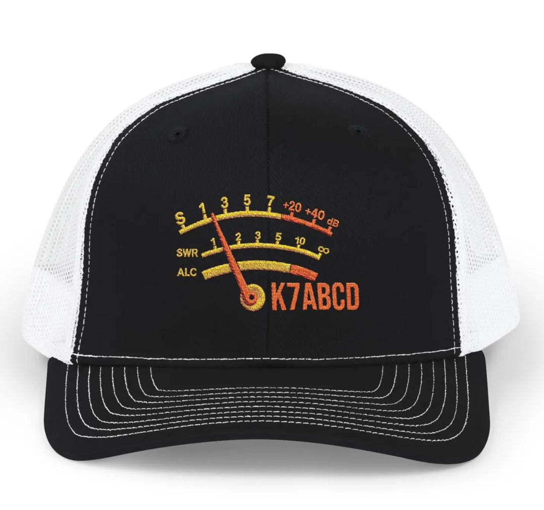 A black and white ham radio callsign Richardson 112 trucker hat featuring a custom embroidered s-meter graphic with the text 'K7ABCD' on the front panel.