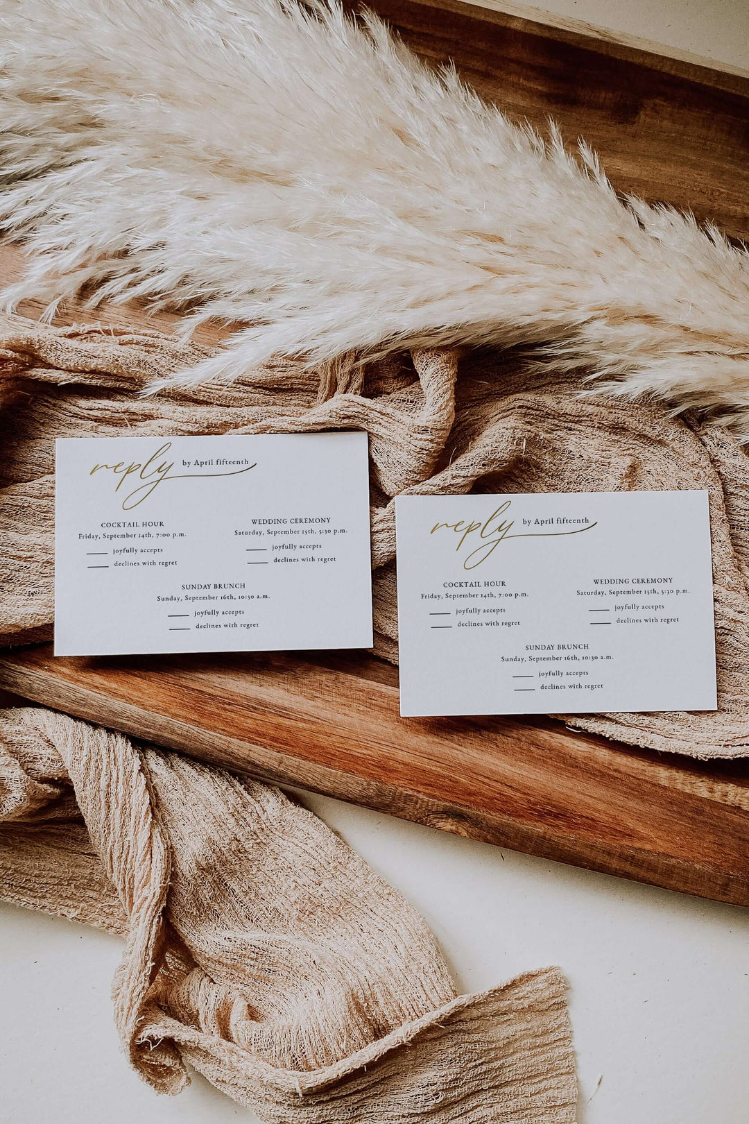 Two wedding invitation rsvp  cards on a textured fabric surface