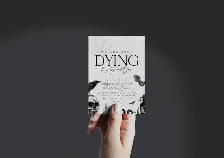 Hand holding a Halloween party invitation with black text and bird illustrations on a dark background